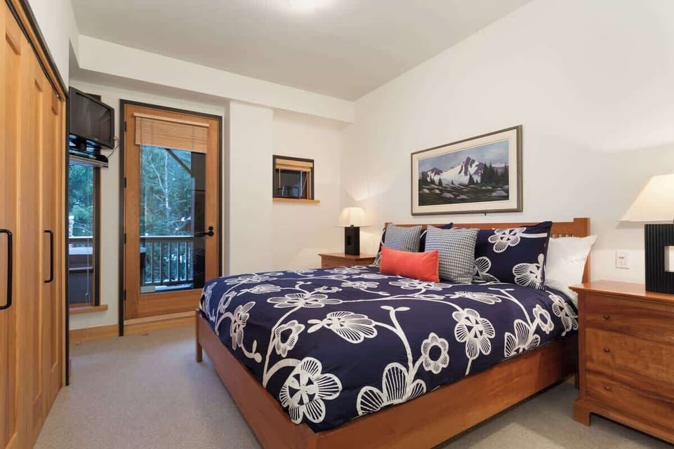 Bedroom 1– Cozy king bedroom with warm wood accents soft bedding and calm forest peeks for relaxing stays
- Bright lamps simple décor and a private door to the outside create an inviting space after mountain adventures