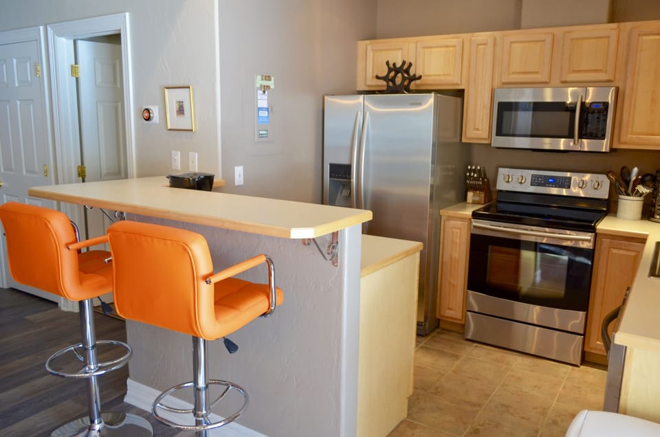 Fully Equipped Kitchen - The kitchen is fully equipped with new appliances, a breakfast bar for extra seating, and open space into the dining area.