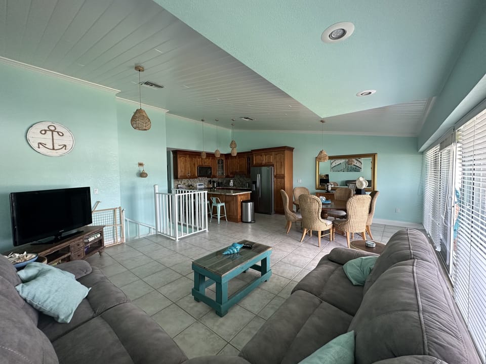 Upstairs living area with kitchen, dining table and outdoor balcony. 