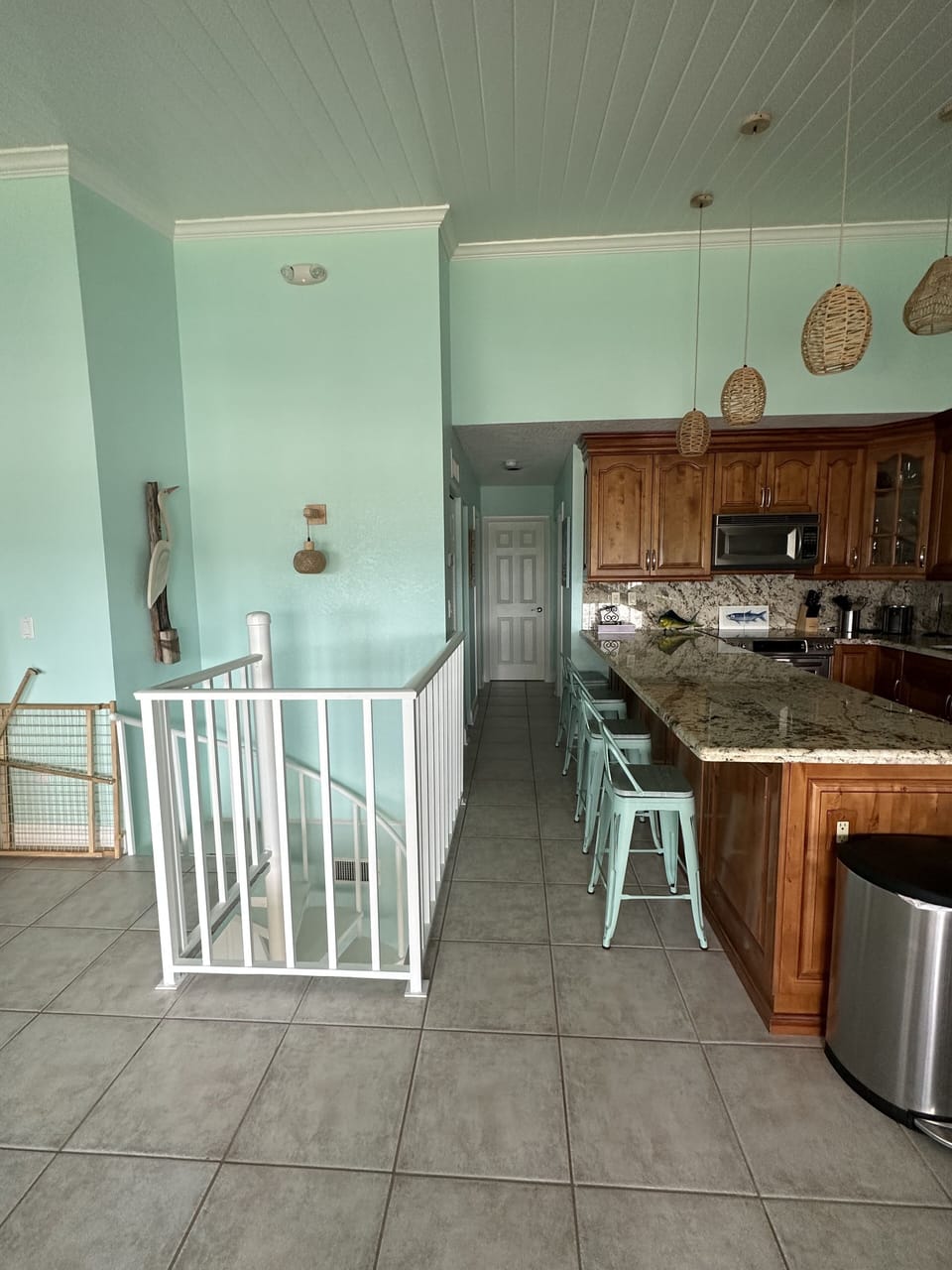 Upstairs living area with kitchen, dining table and outdoor balcony.