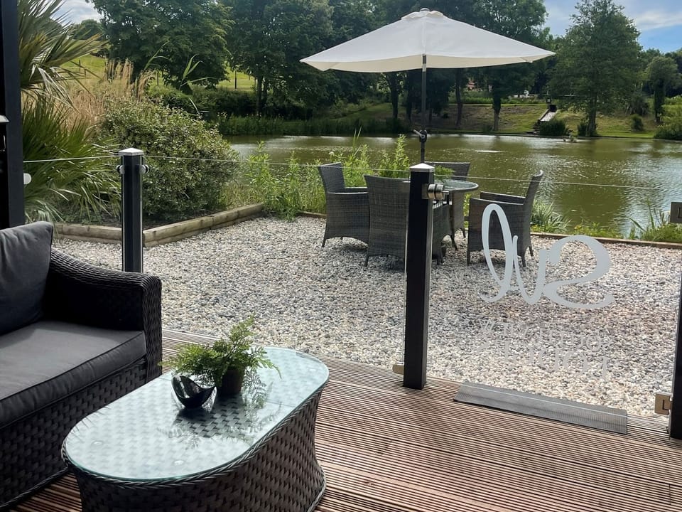 Outdoor area with seating and views to the pond - Kingfisher Lodge