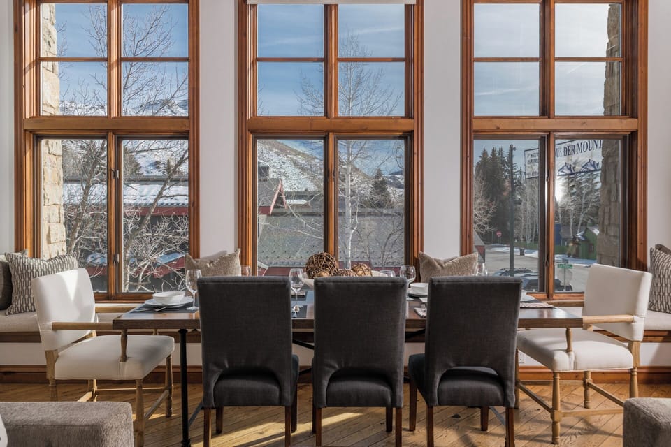 Your elegant dining space showcases mountain views through floor-to-ceiling windows, creating the perfect backdrop for memorable meals together.
