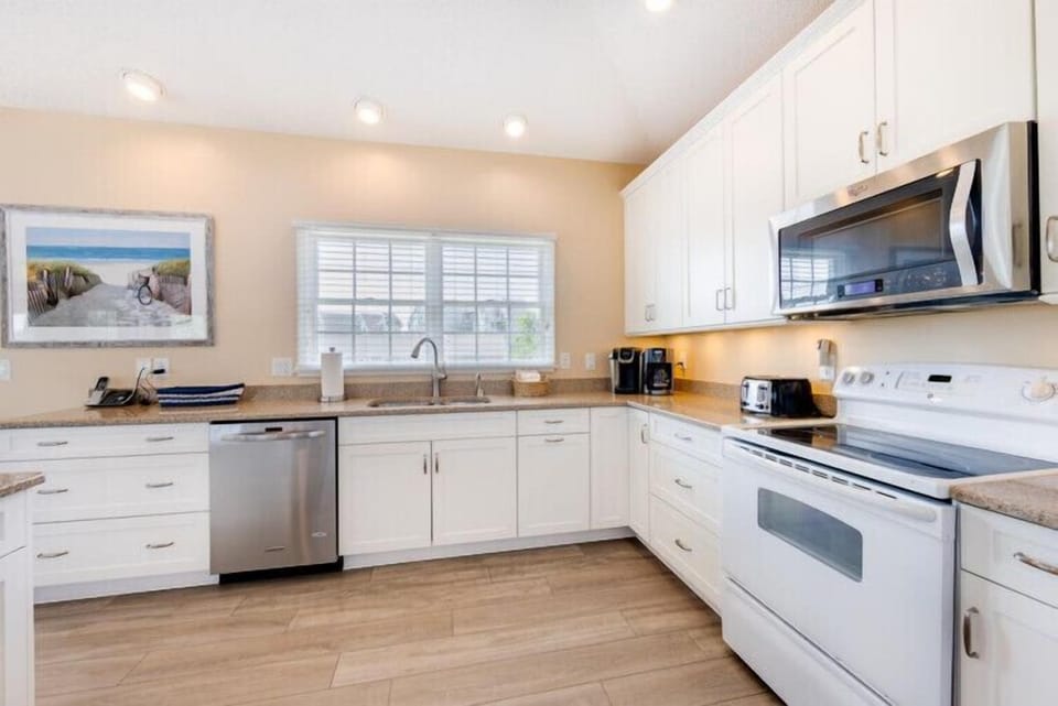 Your spacious kitchen features white cabinetry, stainless steel appliances, and ample counter space—perfect for preparing family meals or morning coffee in comfort.