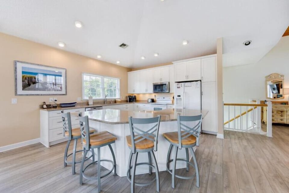 Your open-concept kitchen features sleek white cabinetry, granite countertops, and stainless appliances. Gather at the breakfast bar for morning coffee or casual meals together.
