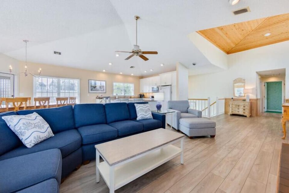 Settle into your inviting open-concept living space with vaulted ceilings and natural wood accents. The spacious layout flows seamlessly from lounge to dining to kitchen, perfect for gathering with loved ones.