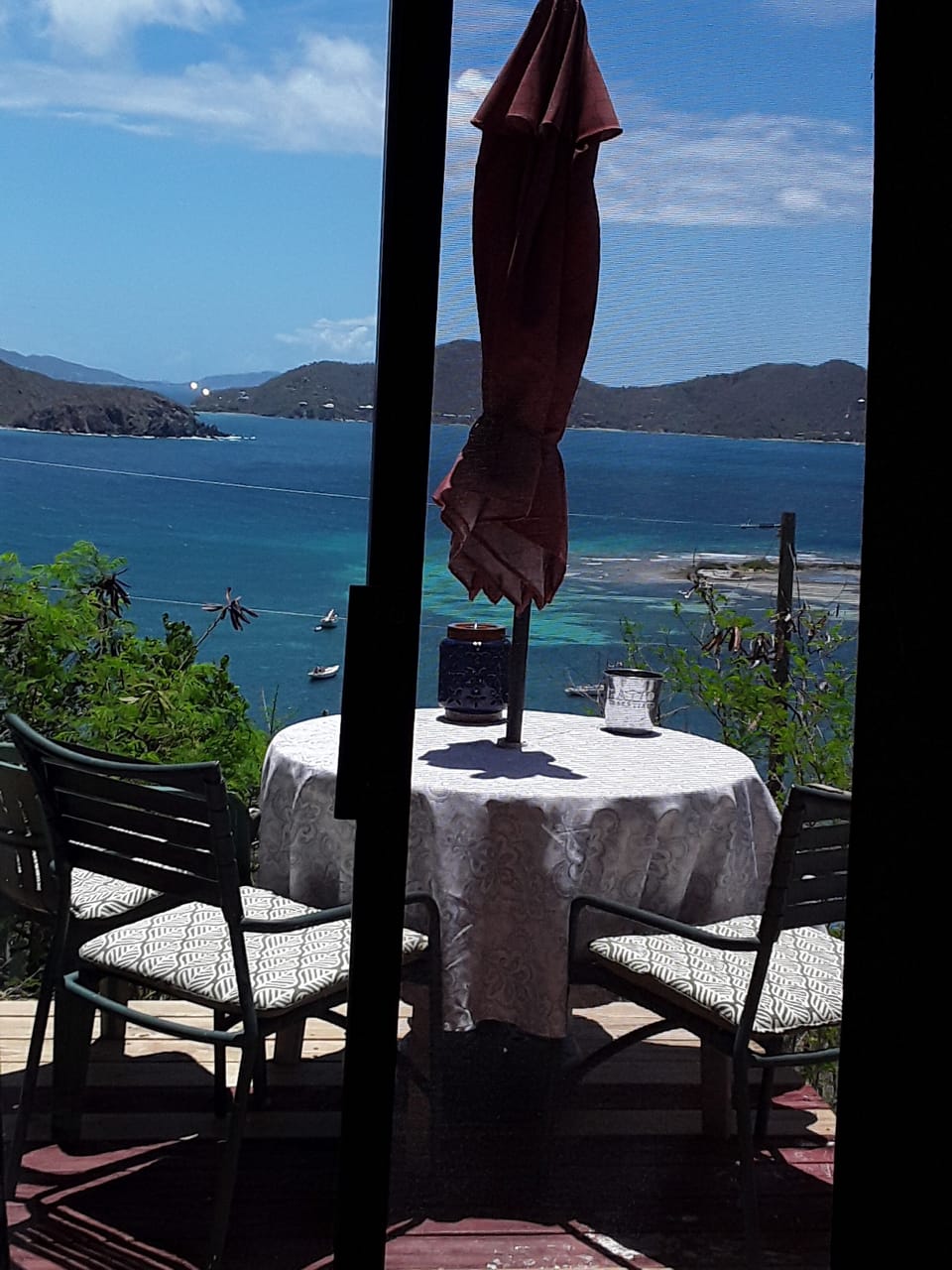 a view of the deck and ocean from the bedroom