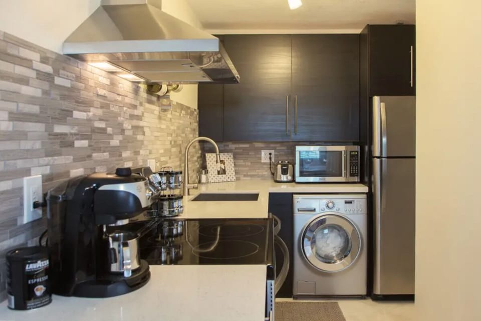 Stainless appliances and LG washer- dryer combo machine in a galley kitchen. 