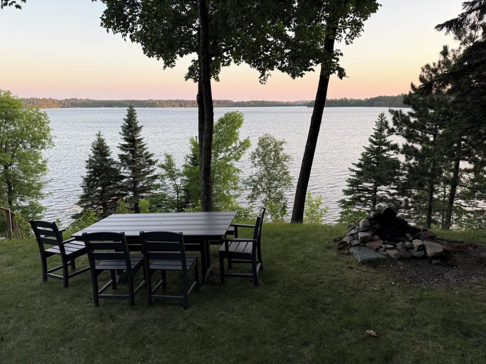 Outdoor dining and seating with Firepit overlooking lake
