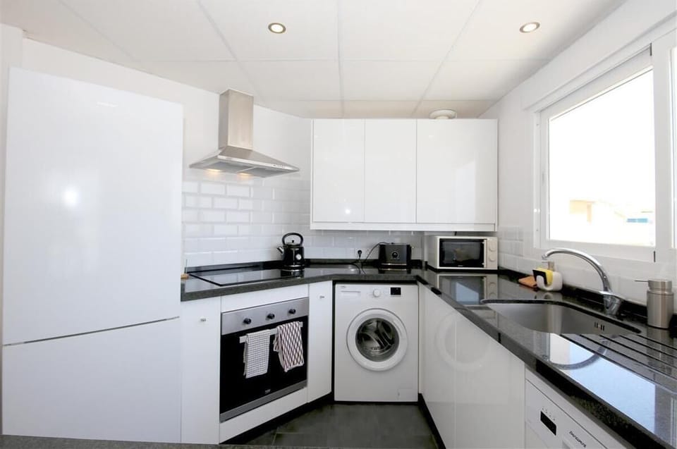 Modern kitchen in this apartment is fully fitted with all the appliances