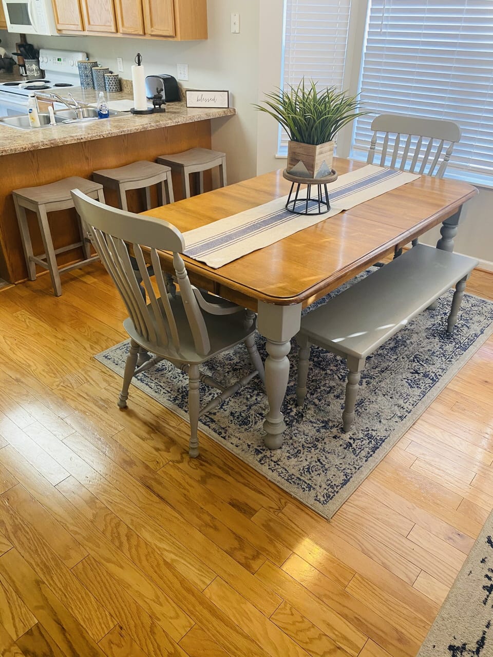 Dining area with dining table and three bar stools. 