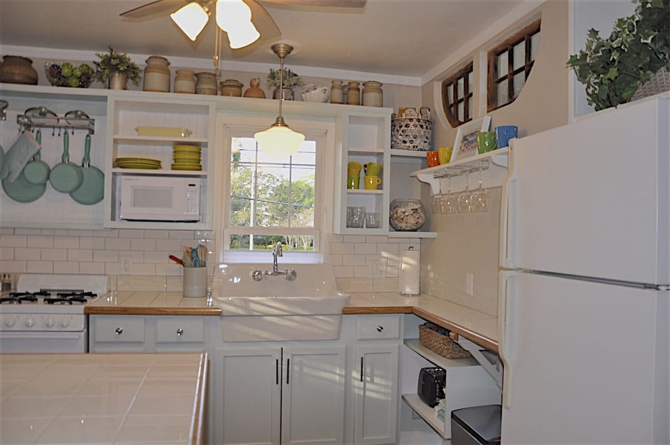 Kitchen cabinets painted soft coastal blue. View of more homes from the sink. 