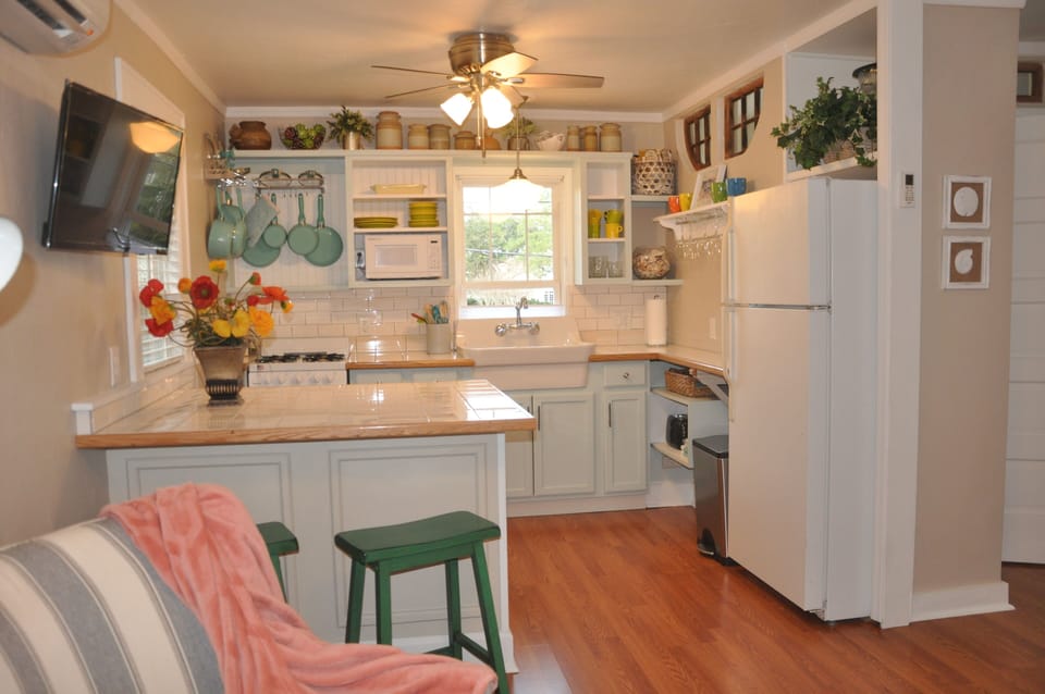 View of kitchen and and peninsula from living room. TV overhead. 