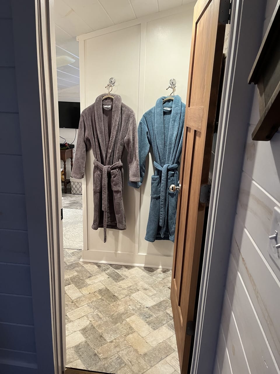 Entrance to bathroom complete with robes, its own heater, AND heated floors