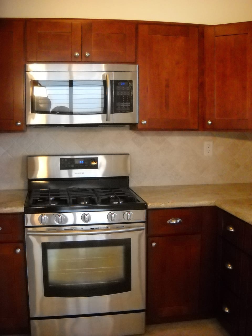 Marble backsplash with granite countertops and extra large microwave