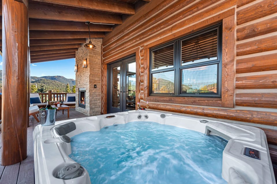 Outdoor patio with hot tub and fireplace