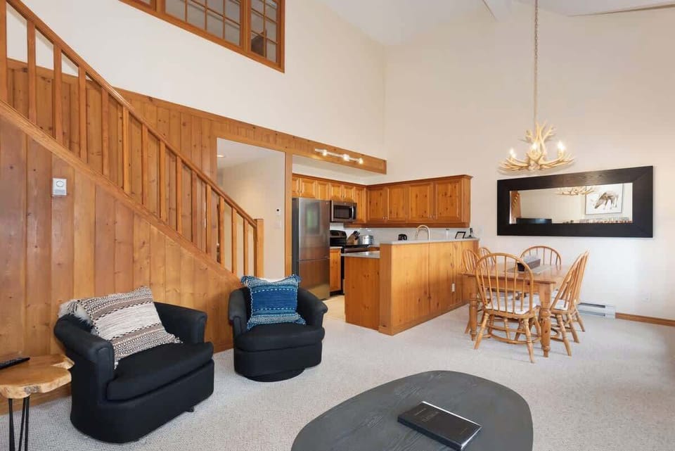 - Open-concept living space with cozy seating and rustic wooden staircase accent  
- Blends cabin warmth with modern design for a relaxing mountain getaway retreat  
- Ideal for families and groups seeking comfort close to trails and outdoor fun  
