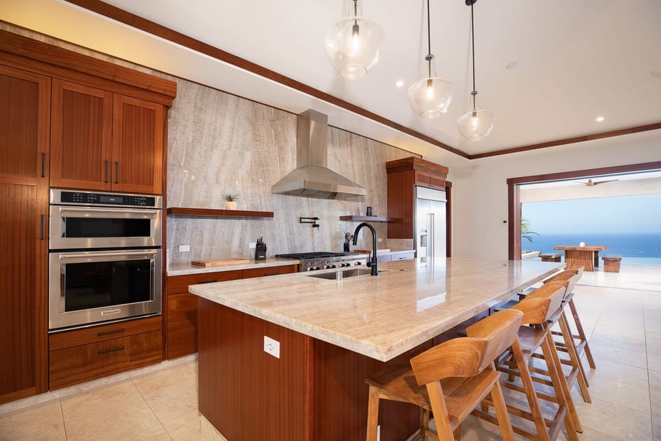 Prepare meals with ease in the kitchen equipped with a six-burner commercial cooktop, convection oven, and high-end appliances.
