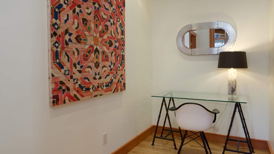 - Minimalist workspace with glass desk and creative wall art  
- Bright and quiet corner ideal for reading or remote work  
- Designed for focus with modern alpine simplicity  