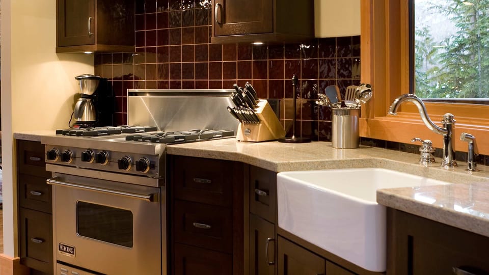 - Professional-grade stove and farmhouse sink for easy prep  
- Warm wood cabinetry paired with glossy tiled backsplash  
- Fully equipped kitchen for effortless mountain cooking  