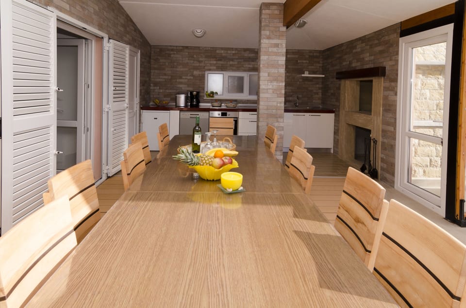 Big outside dinning table and kitchen with barbecue area