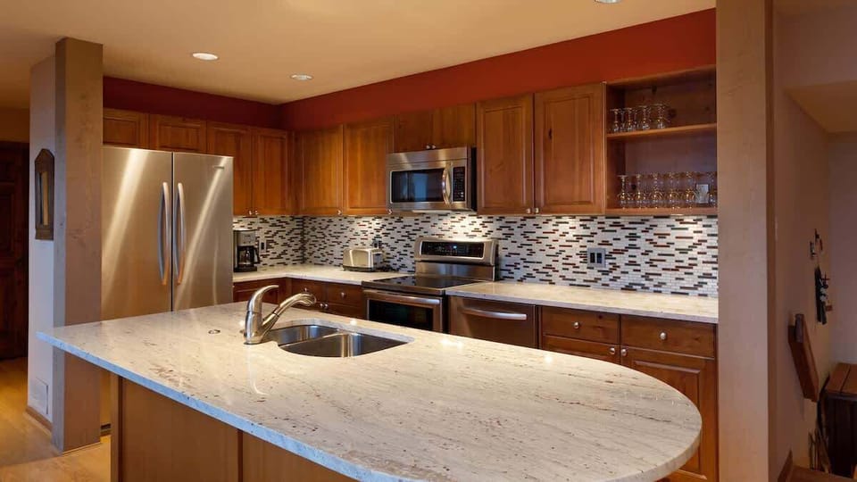 - Modern kitchen with sleek granite counters and full stainless-steel appliances  
- Warm wood cabinetry and open layout perfect for cooking and entertaining  
- Ideal for preparing hearty après-ski meals with family and friends  