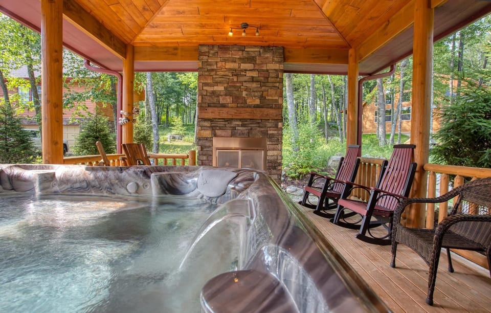 Covered porch has a hot tub, gas fireplace, and plenty of seating
