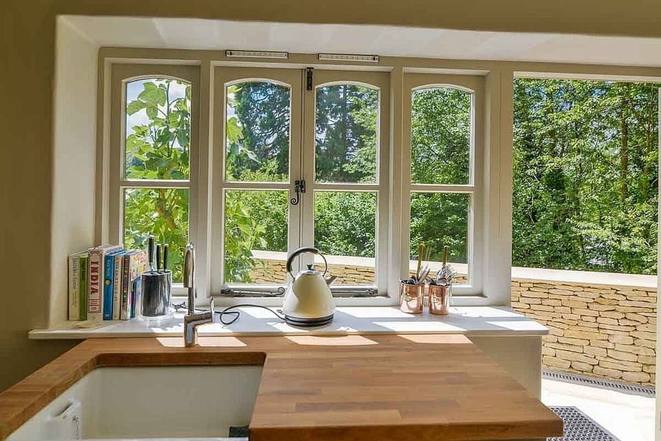 The kitchen has been well designed and has great views across the wooded valley.