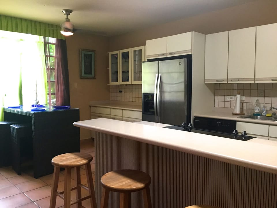 The breakfast nook beside the window with garden views and kitchen island 