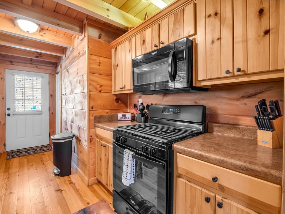 Cozy cabin kitchen with modern appliances and rustic wood cabinetry.