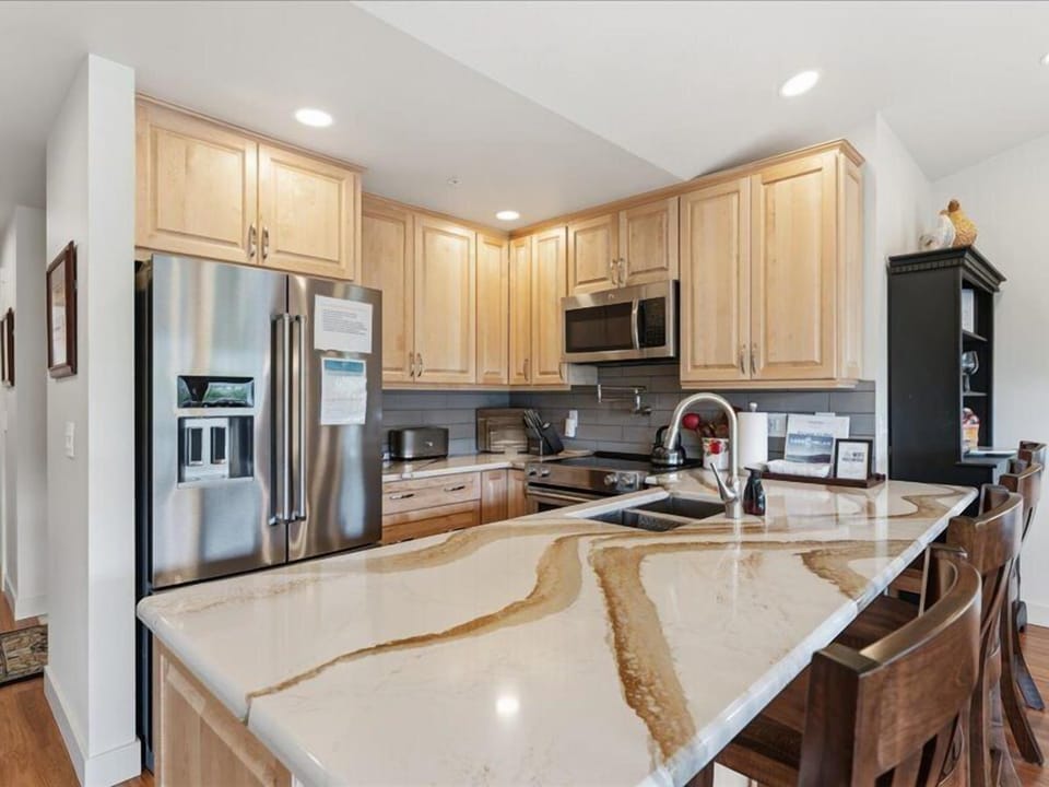 Step into your fully-equipped kitchen, where gleaming granite counters and stainless steel appliances invite you to whip up your favorite meals in style and comfort.
