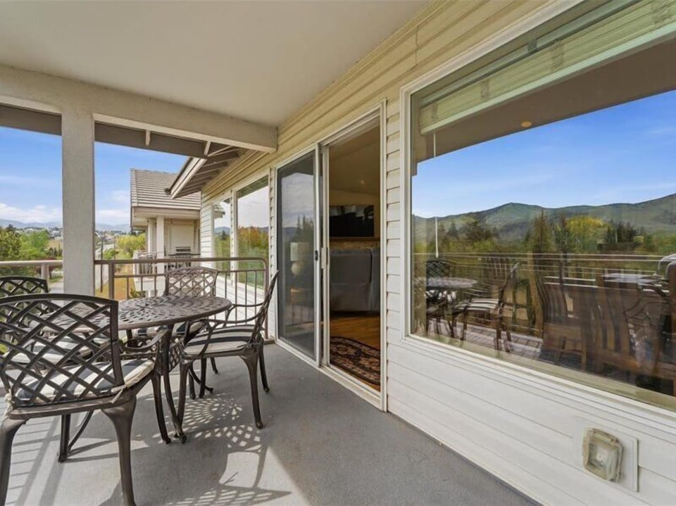 Sip your morning coffee on this private balcony with sweeping mountain views. The outdoor dining setup invites you to enjoy meals al fresco while soaking in the peaceful scenery.