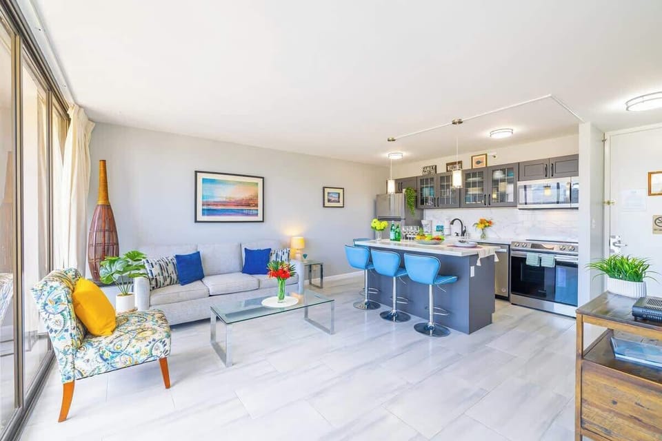 Bright open-concept living area with a modern kitchen island and seating for four.