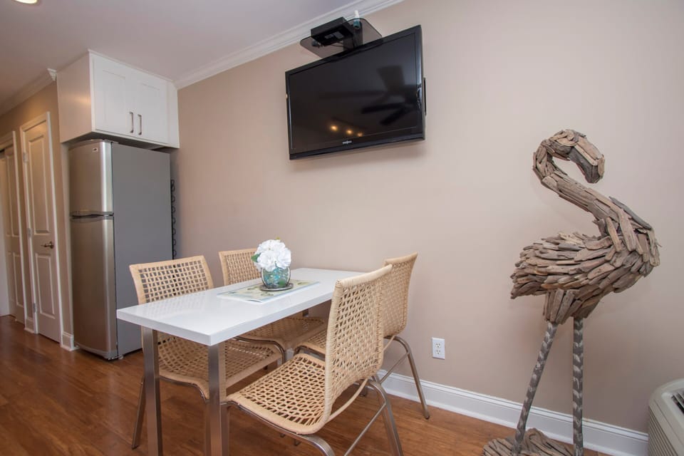 Seaside Villas 238 - Dining Area - The large, wall-mounted flat-screen TV is centrally placed so it can watched from the dining table or the sofa.