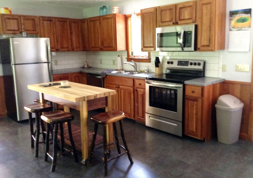Kitchen with all new appliances, custom cabinetry, island, and stools