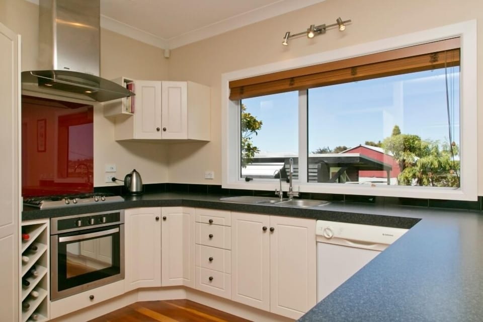 Kitchen with dishwasher, oven, gas hob, full fridge/freezer, and breakfast bar.