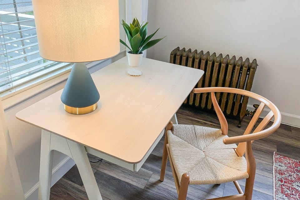 Queen Bedroom—Featuring a dedicated workspace equipped with ample outlets, USB chargers, high-speed Wi-Fi, and abundant natural light. 