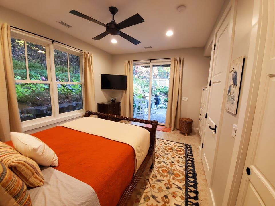 Main floor Guest Bedroom w/TV and sliding doors to access outdoor covered patio.