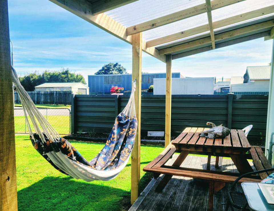 Covered back porch for outdoor dining. Enjoy the hammock!