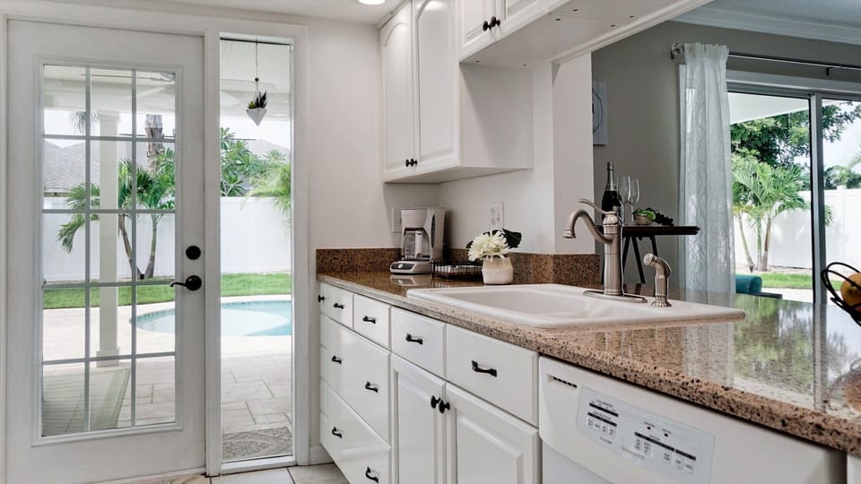 Galley style kitchen, that has door to the pool and a dishwasher.