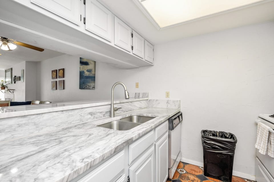 Cook comfortably in your bright galley kitchen with marble countertops, stainless steel appliances, and plenty of cabinet storage.