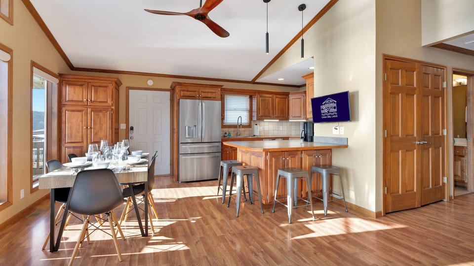 Open kitchen, dining and living room area with enough dinnerware for 12 people.