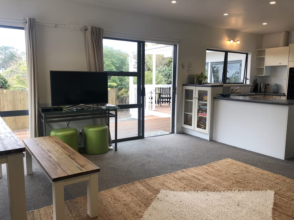 Lounge & dining flow to decks with BBQ, lounger & chairs.