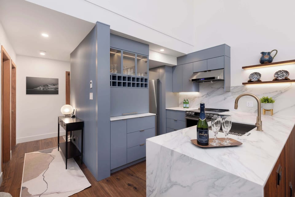 - Modern kitchen with marble island and open wine rack display  
- Stainless steel appliances and cozy ambient lighting throughout  
- Perfect setup for cooking, dining, and entertaining guests  
