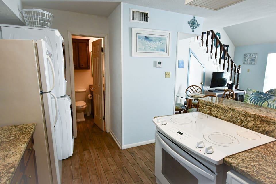 Your fully-equipped kitchen features granite countertops, modern appliances, and coastal charm—perfect for preparing meals during your beach getaway.