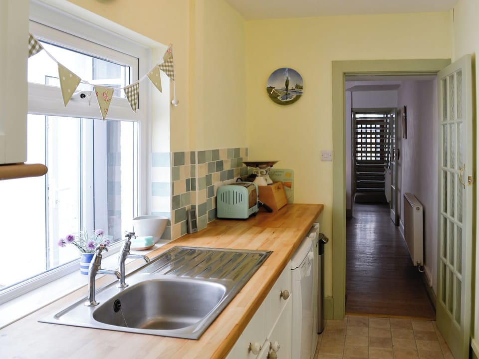 Galley style kitchen with view over the garden and patio | Llys Deulyn, Trefriw, near Betws-y-Coed