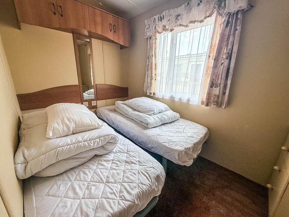 This welcoming space features two snug single beds, providing a perfect spot for rest after a day of fun on the Norfolk coast.