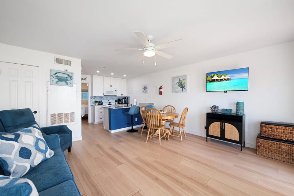 Step into your bright, airy retreat with coastal charm. Relax in the open living space, enjoy meals at the dining table, and take in the tropical vibes throughout this welcoming home.