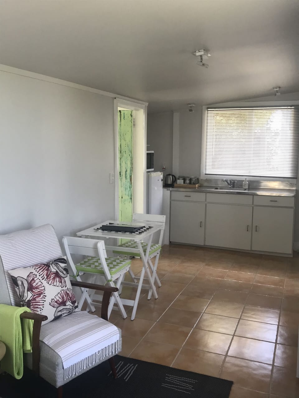 Cafe style table and chairs facing kitchenette area 