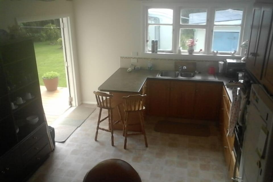 the roomy sunny self-contained kitchen with the french doors open