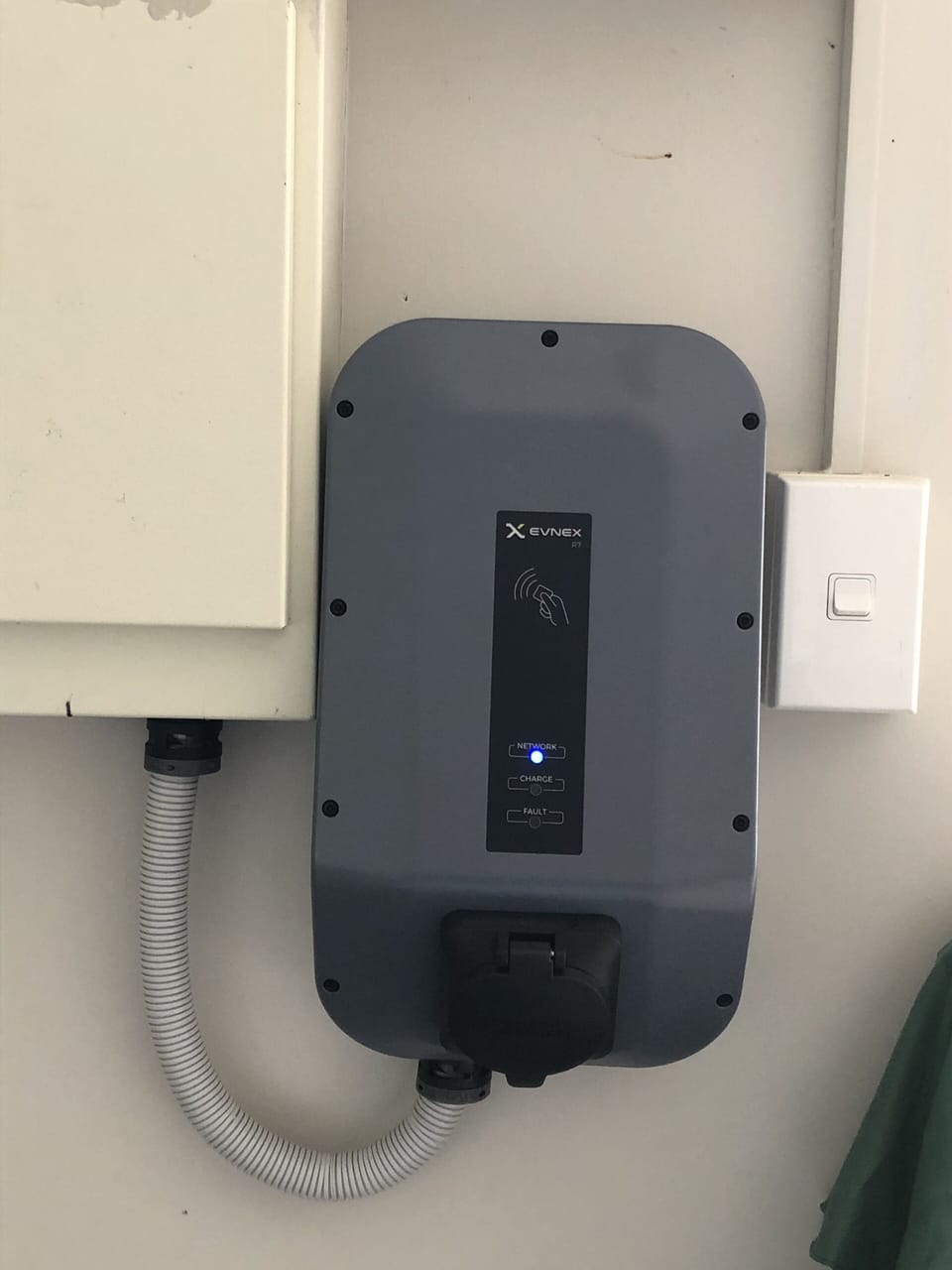 There is an EVNEX electric vehicle smart charger in the garage